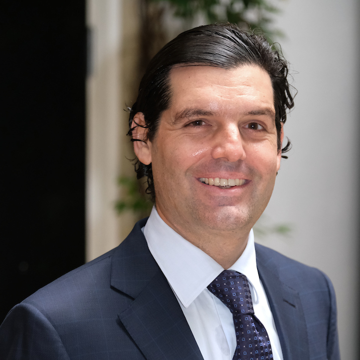 A headshot of Alejandro Betancourt Lopez wearing a dark blue suit